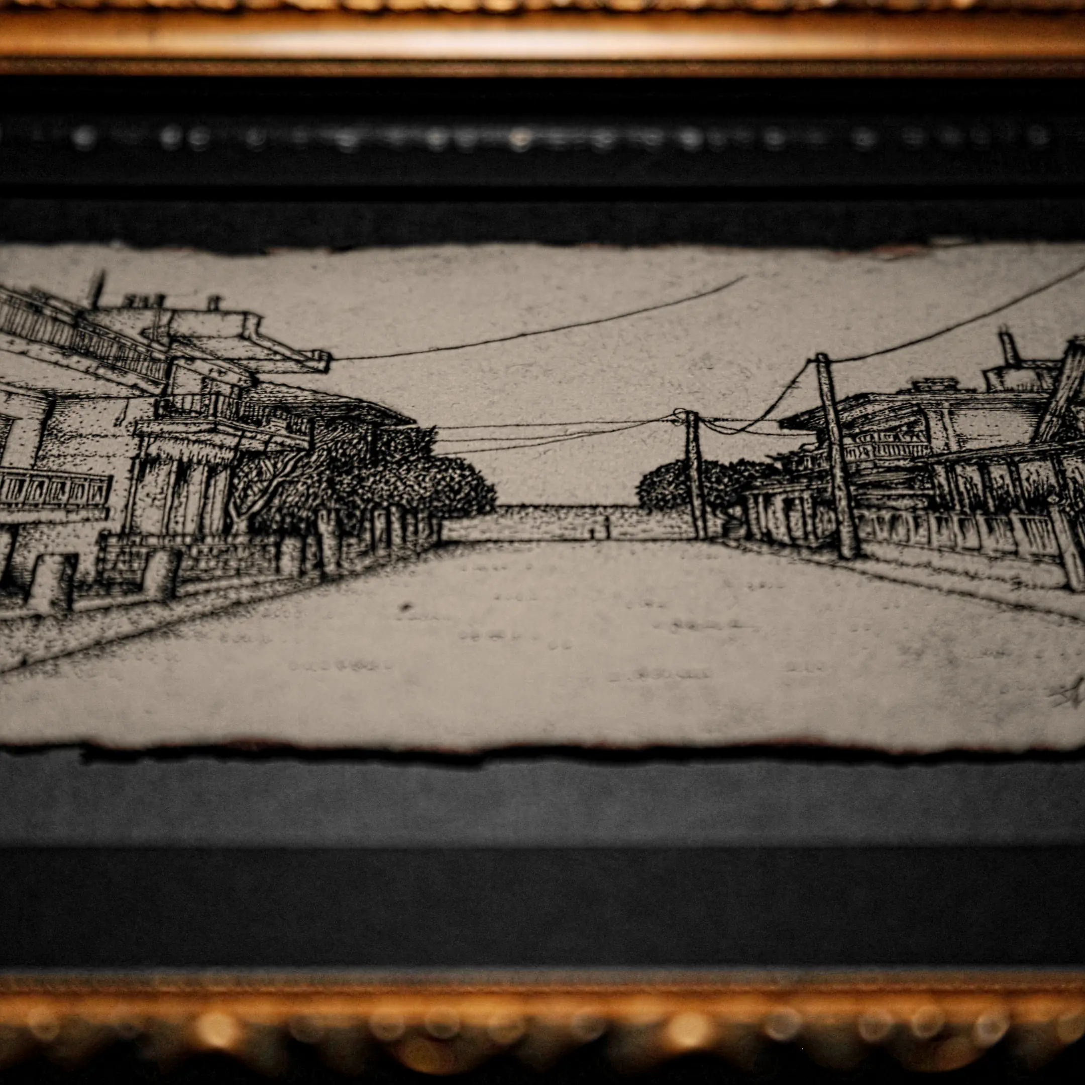 A panoramic ink drawing titled "Siesta" on deckle-edged paper, set within a black mat and a classical gilded gold frame.