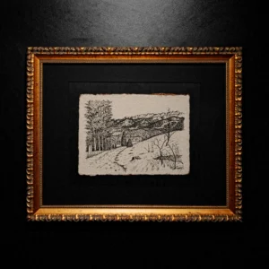 An ink mountain landscape drawing with deckled edges, set in a black mat and an ornate gold frame against a dark wall.