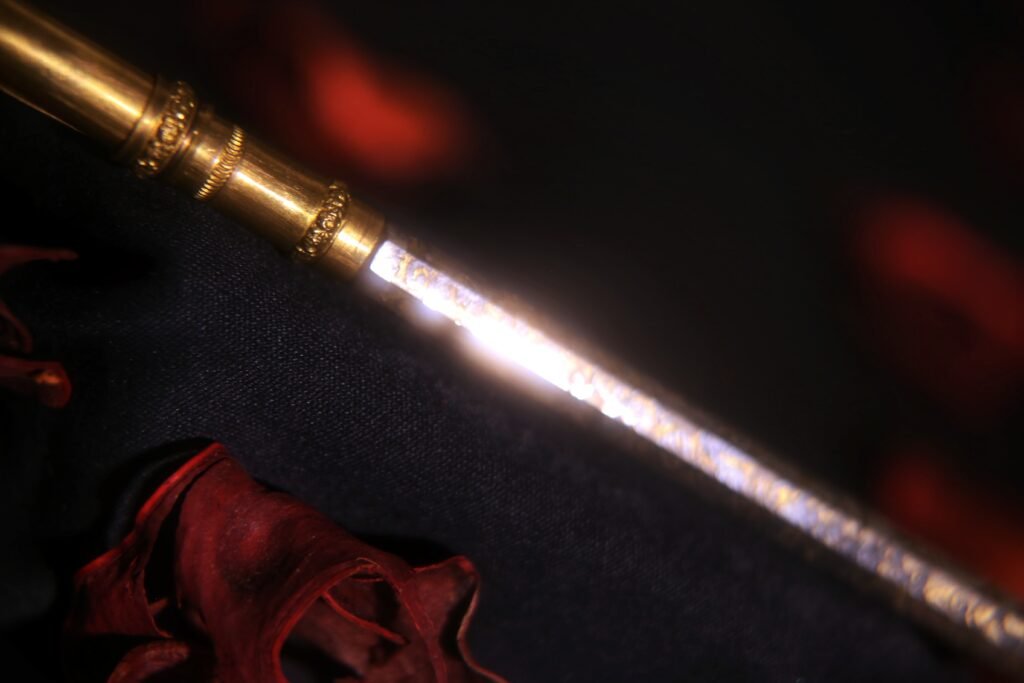Macro close-up of the gold-toned section of an antique ink pen, highlighting light reflections.