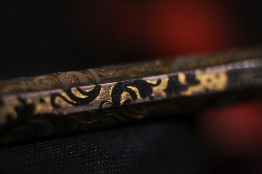 Macro detail of the intricate engraved pattern on the handle of an antique ink pen.