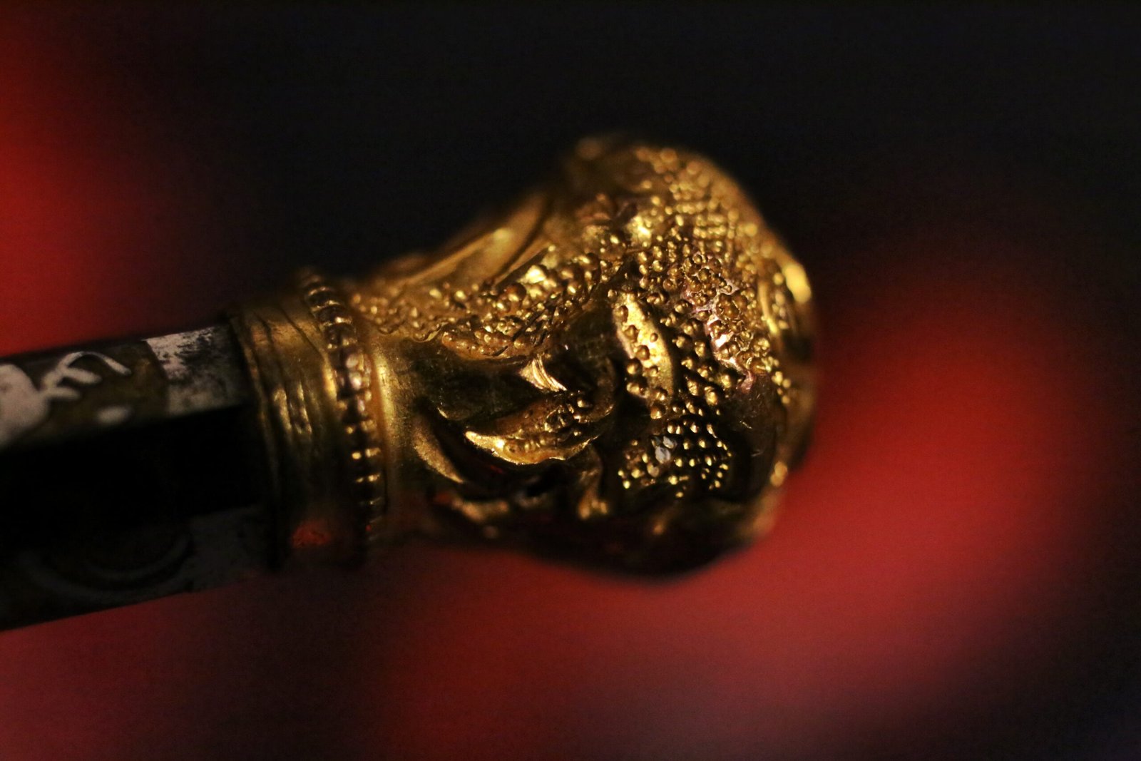 Macro close-up of the detailed gold finial on an antique ink pen.